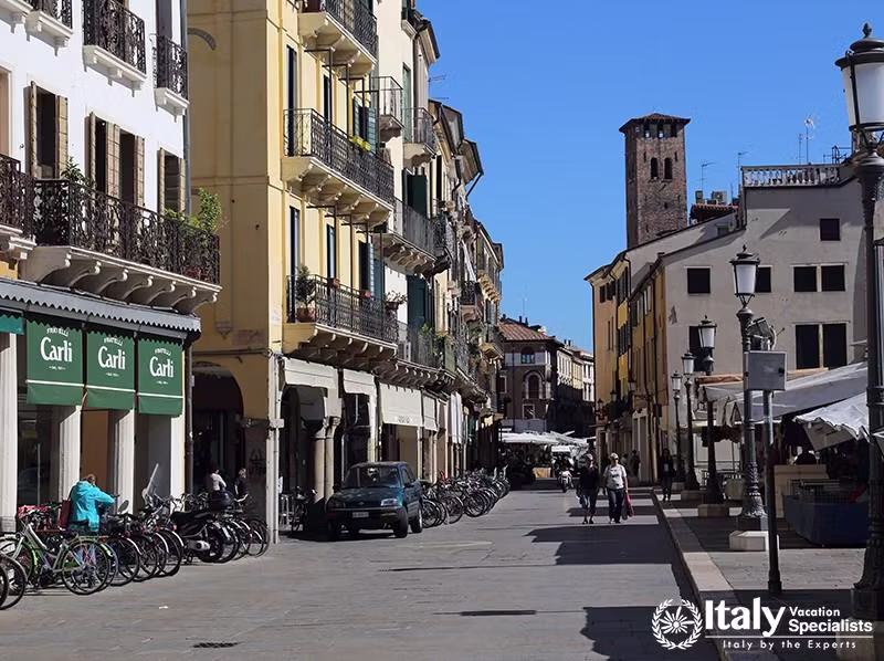 Shops on Piazza dei Signori square and people walking in the street in Padua, Italy on September 28,