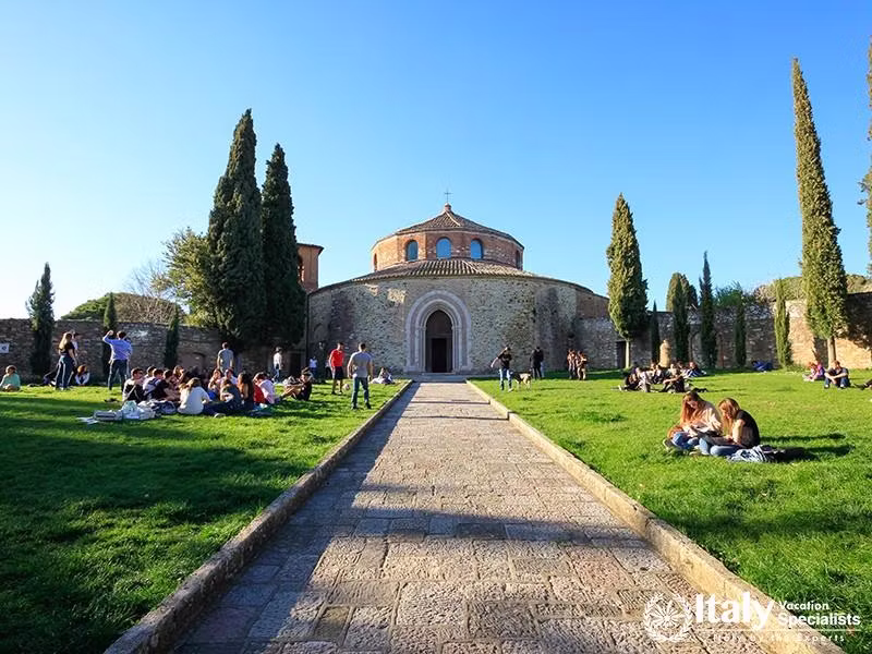 University students studying and playing in the field in front of the Church of Sant Angelo, a pale