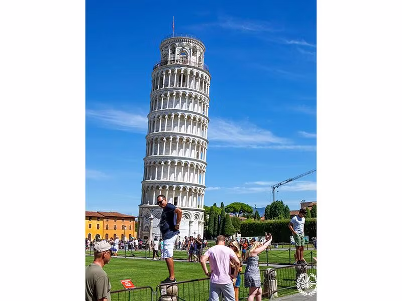 Photo of Tourists are photographed against the background of the Leaning Tower. Livorno ITaly