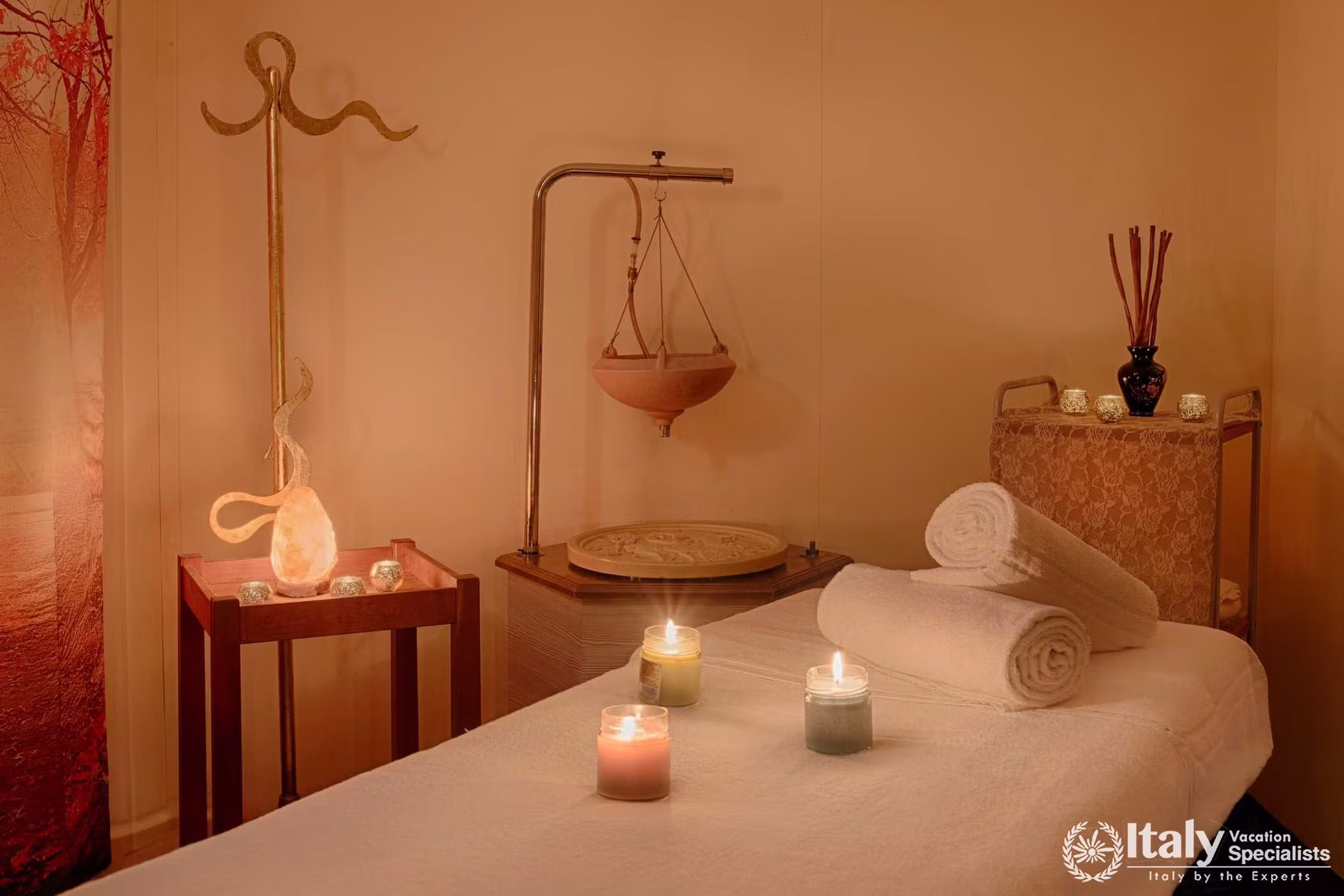 Candlelit massage room at the beauty centre of UNA Hotels Capotaormina with folded towels, oils and warm lighting