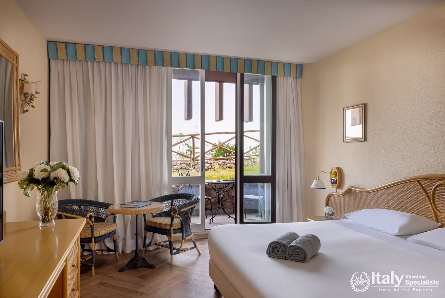 Superior Room at UNA Hotels Capotaormina with a double bed, striped pelmet curtains and a balcony overlooking the garden