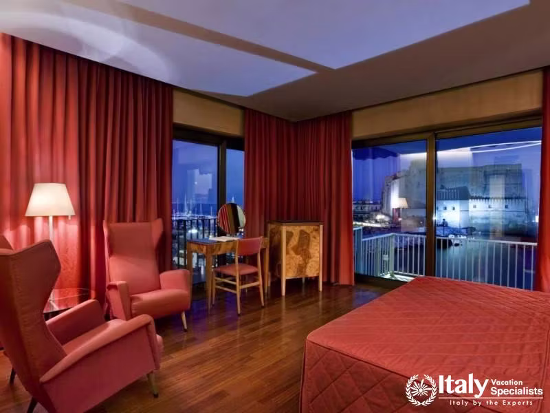 A luxurious red-themed room with a nighttime sea view.