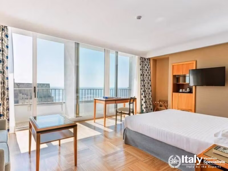 A well-lit room with floor-to-ceiling windows offering panoramic sea views.