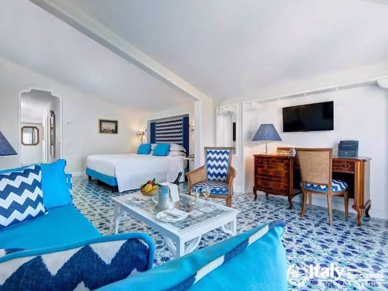 Spacious suite with vibrant blue accents and cozy seating.