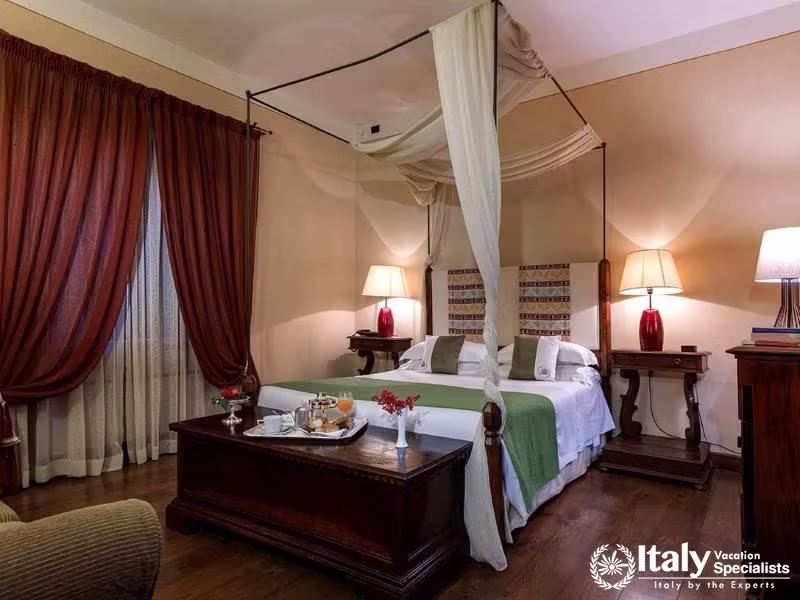A warmly decorated room with a canopy bed and classic wood furniture, radiating old-world charm.