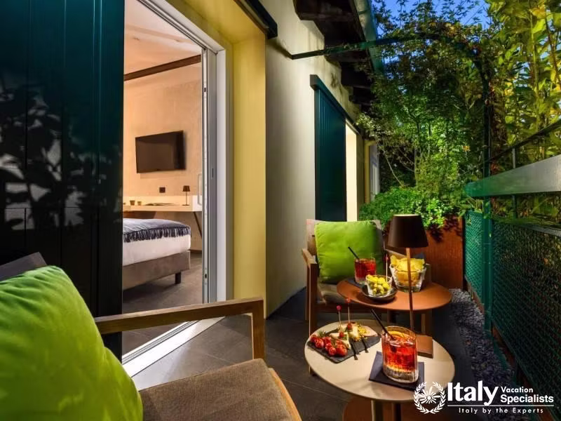 Experience tranquil evenings on a private balcony with lush greenery and elegant seating.