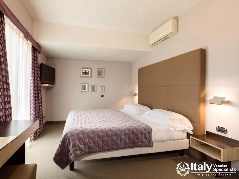 A modern, comfortable suite with a cozy bed and minimalist design in soft, neutral tones.