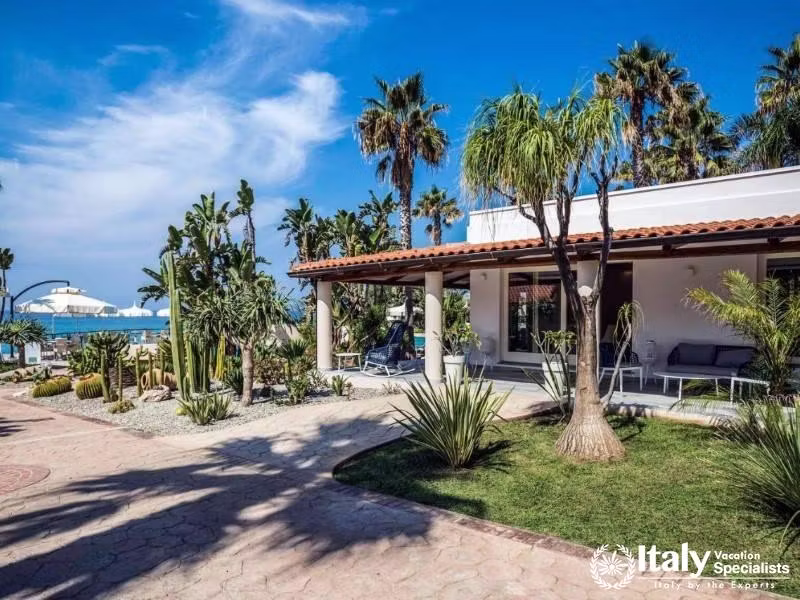 Villaggio Il Gabbianos pathway leads through lush landscaping to a seaside oasis.