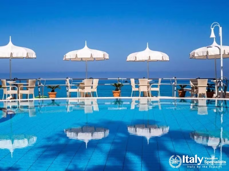 Poolside tranquility under white umbrellas at Villaggio Il Gabbiano.
