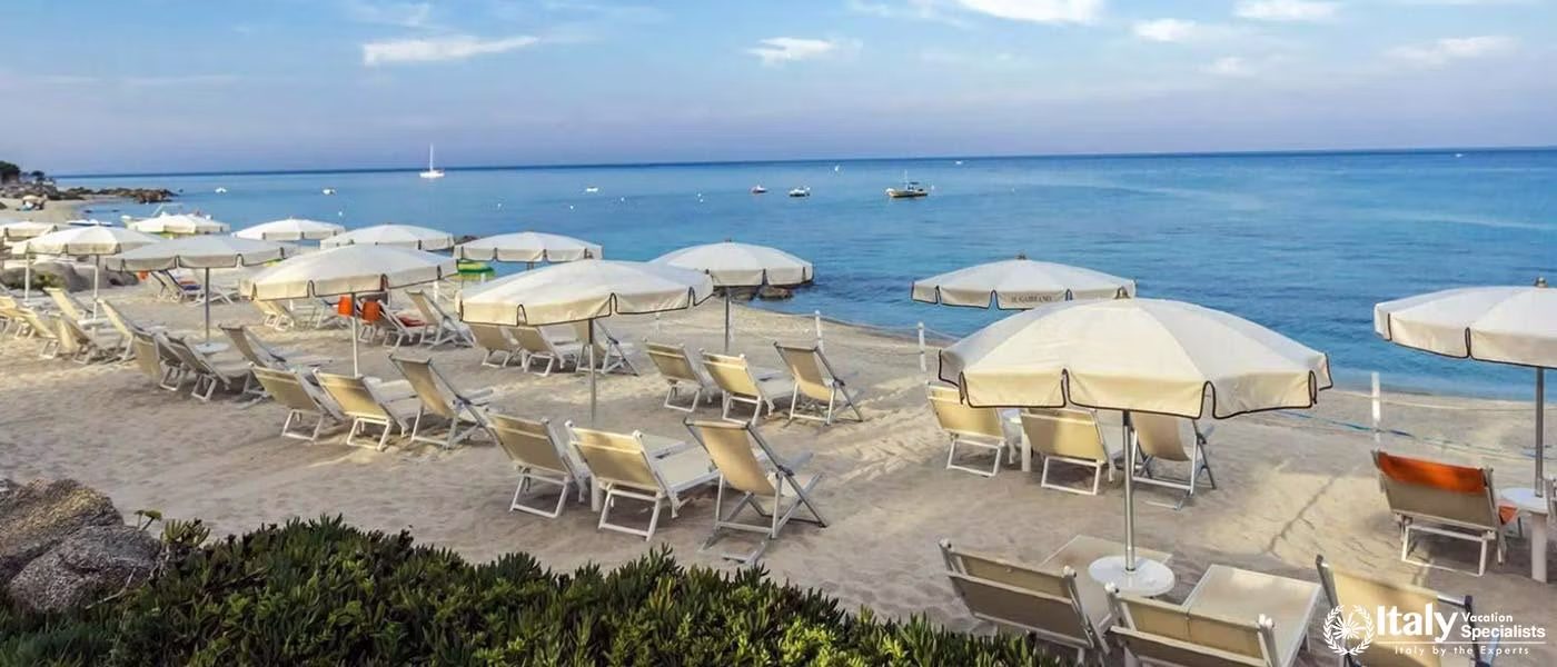 Sun loungers await on the sandy beach of Villaggio Il Gabbiano