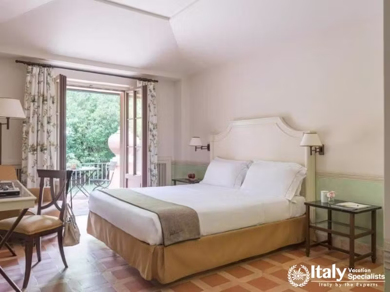 Cozy bedroom with balcony overlooking tranquil gardens at QC Termeroma Spa and Resort