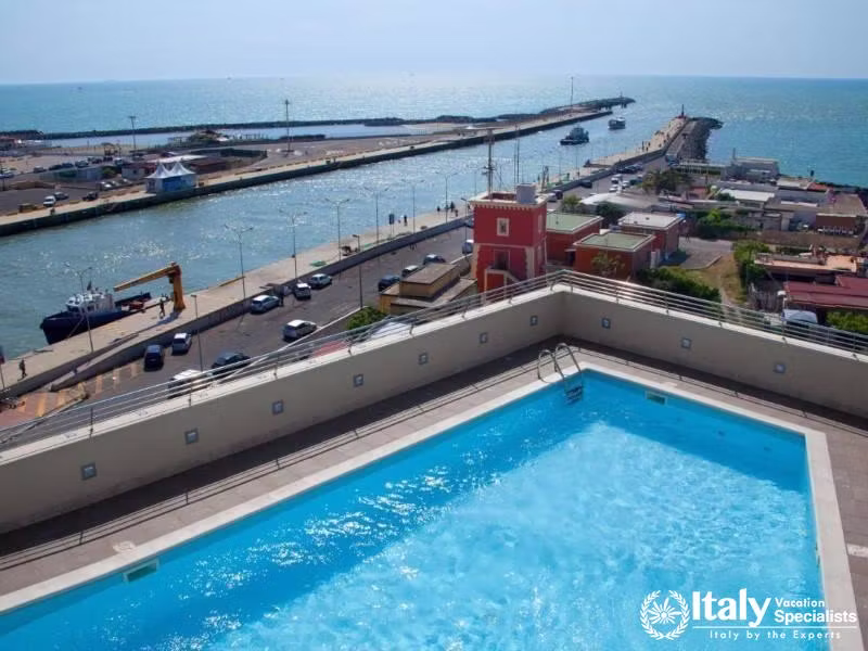 A rooftop pool offering panoramic views of the sea and surrounding harbor area.