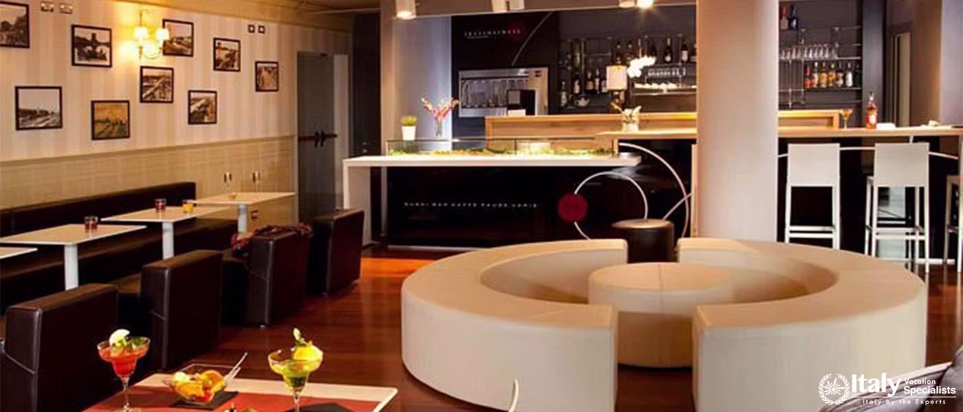 A cozy and modern hotel bar with circular seating arrangements and a well-lit, stylish counter.