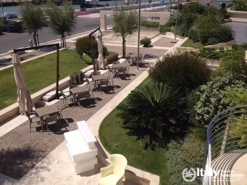 A peaceful outdoor seating area with umbrellas and garden surroundings.