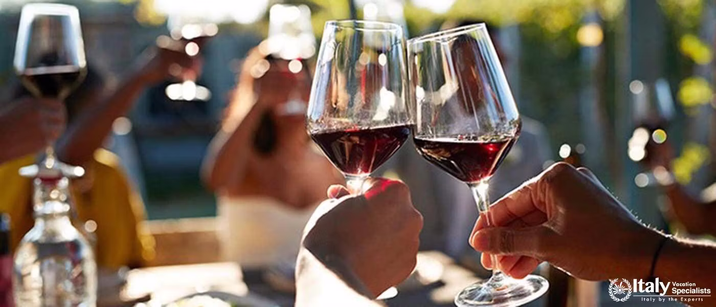 Guests enjoying a toast with Guardastelle's exquisite wines under the Tuscan sun.