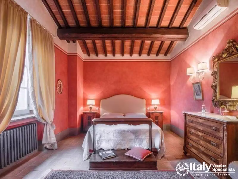 A cozy and romantic bedroom adorned with traditional Tuscan decor at Guardastelle Winery.