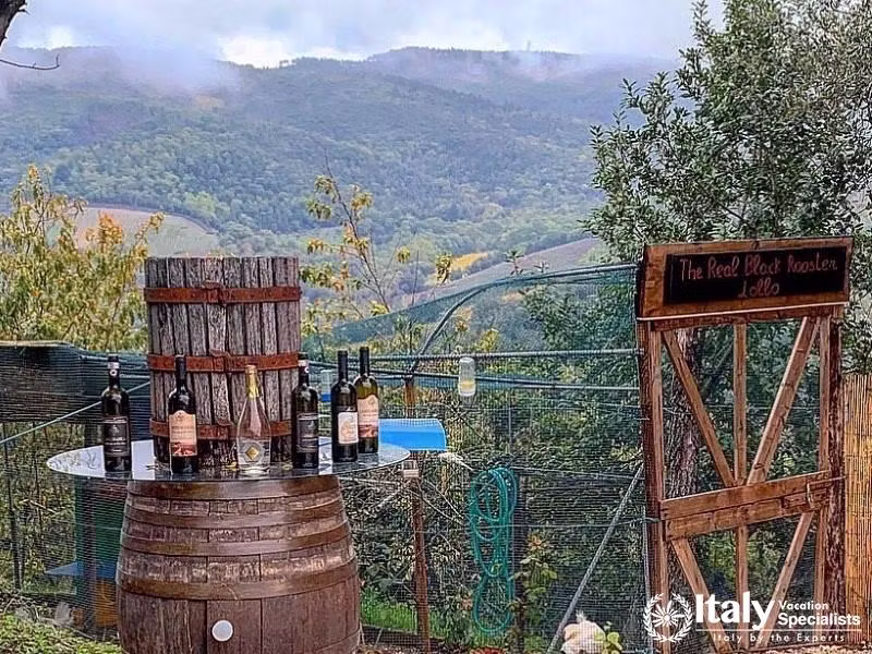 A rustic wine display set against the breathtaking backdrop of the Tuscan hills.