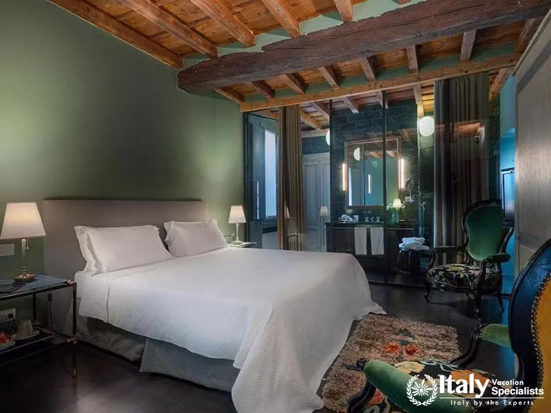 Warm and elegant suite at Hotel Maison Borella with wooden-beamed ceilings.