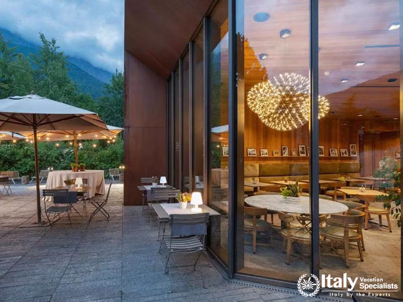 Outdoor Terrace with Dining Setup and Night Lights in Eden Hotel