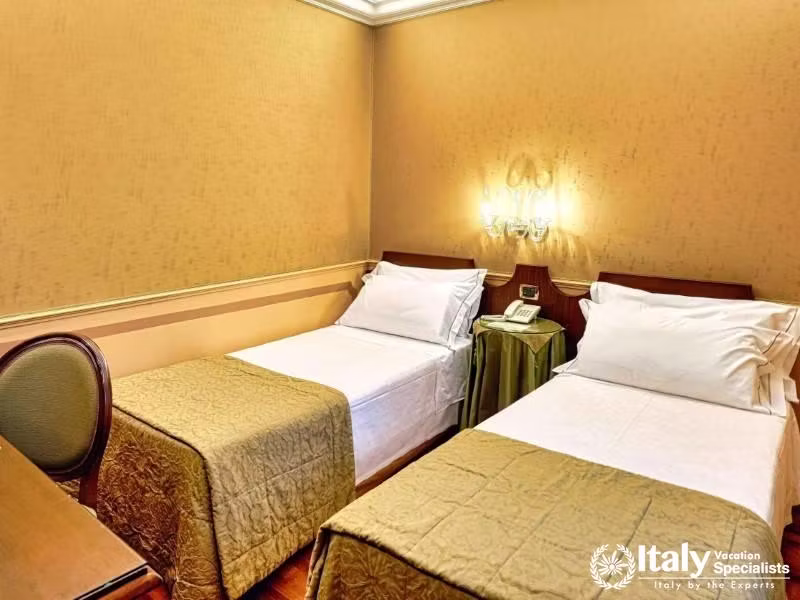 Twin single beds offer a comfortable stay for companions at Hotel Al Codega.