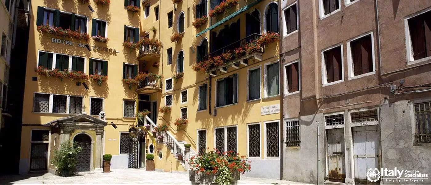 A quaint courtyard view of the warm, yellow Hotel Al Codega.