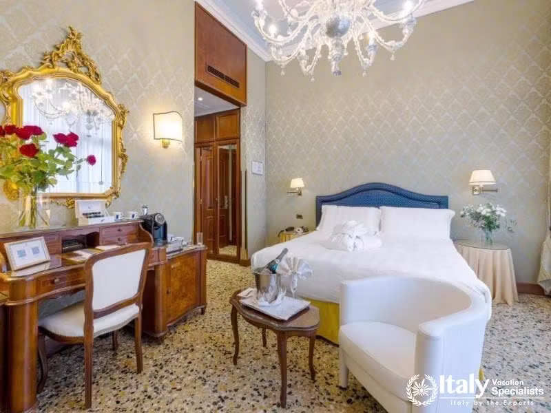 Refined elegance with a touch of Venetian opulence awaits in this serene bedroom at Hotel Colombina.