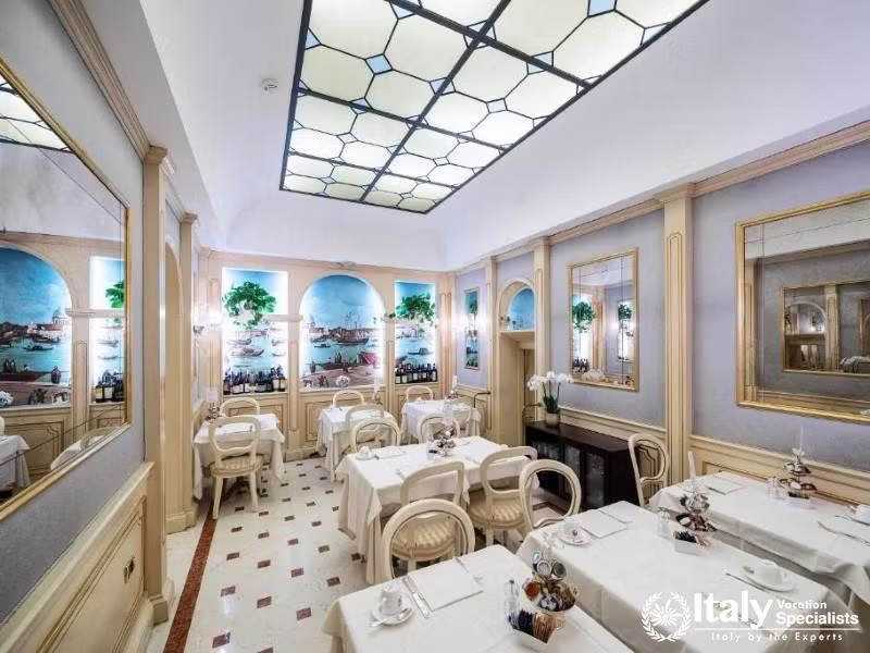 The breakfast room offers an intimate dining experience with mural-adorned walls at Hotel Colombina.
