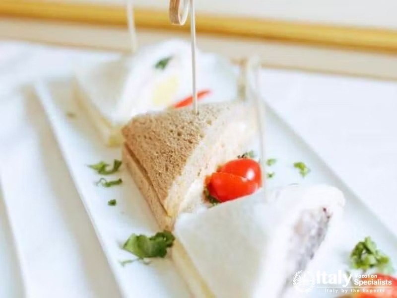 Delight in dainty sandwiches amidst elegant decor at Hotel Colombina.