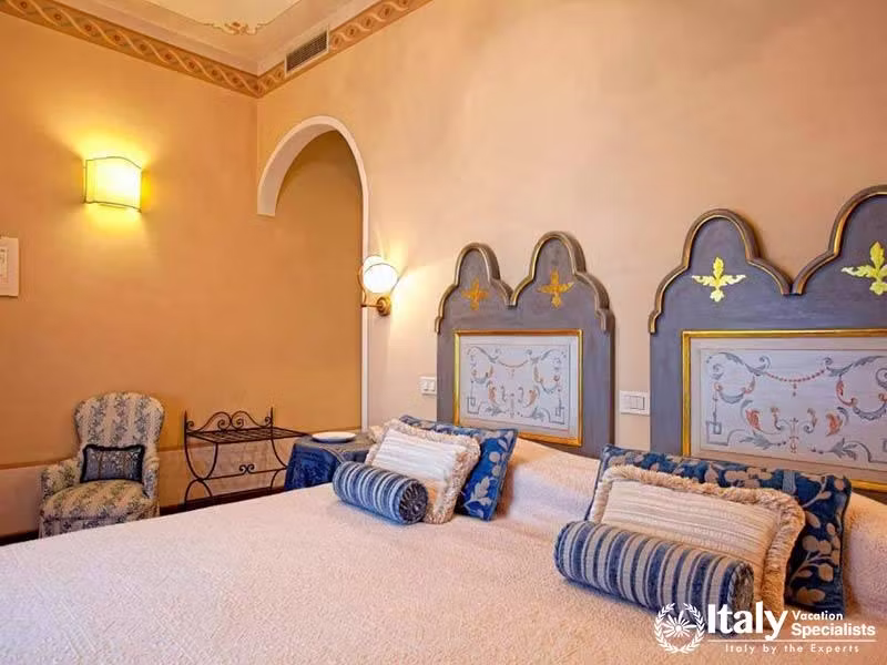 Beautifully Decorated Bedroom with Artistic Headboards at Hotel Villa Marsili in Cortona, Italy