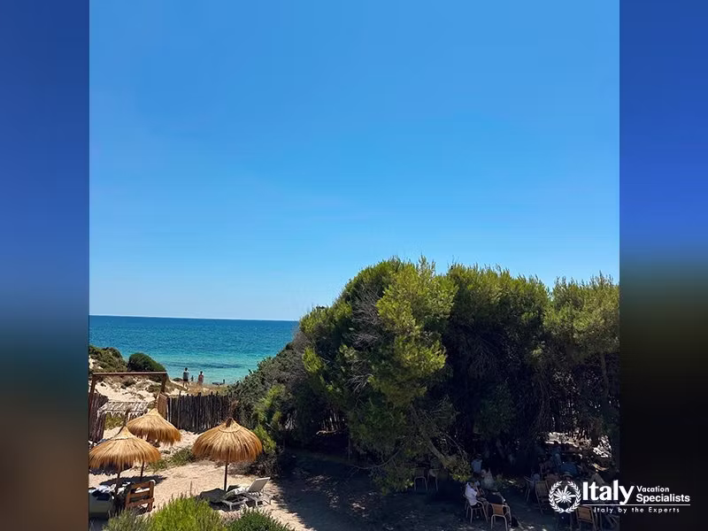 Elevated view of the beach and shaded dining area in La Casa sul Mare