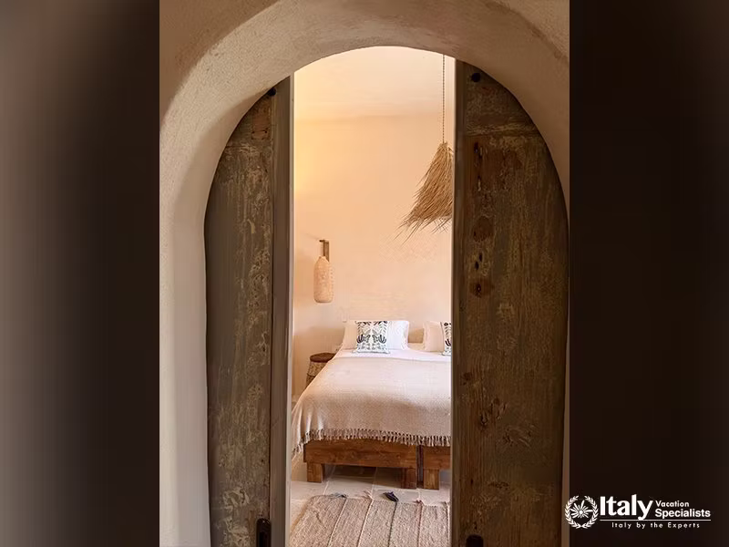 Bedroom viewed through the arched doorway in La Casa sul Mare