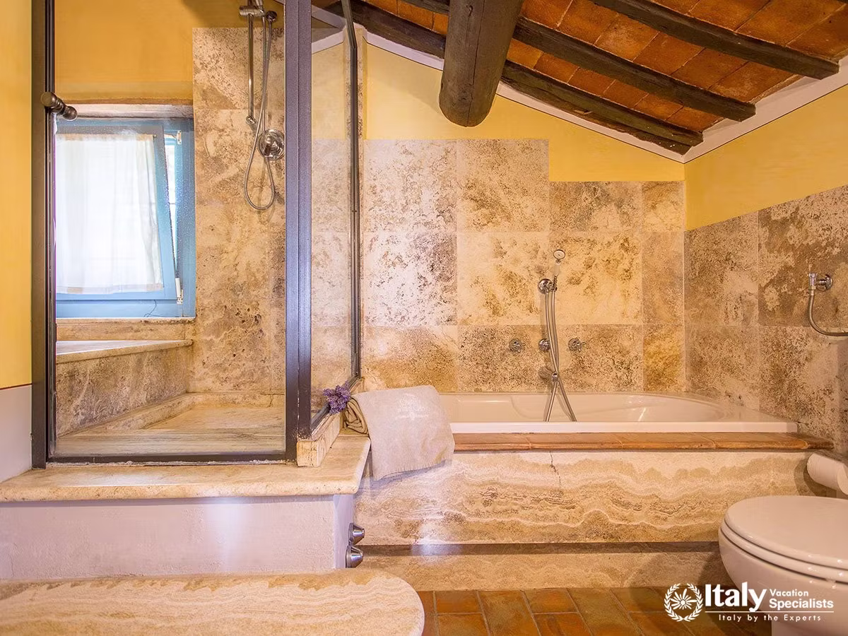 Stone-Finished Bathroom with Bathtub and Shower at Villa San Martino