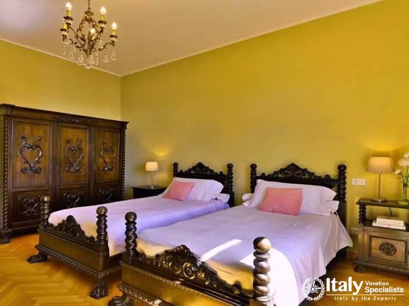 Regal Comfort: Spacious bedroom featuring ornate wood furniture and warm tones in Villa Lago Elegant