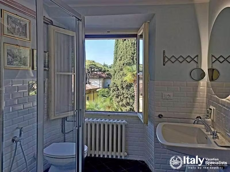 Bright, Tiled Bathroom: A fresh, airy bathroom offering lush external views in Villa Lago Elegante