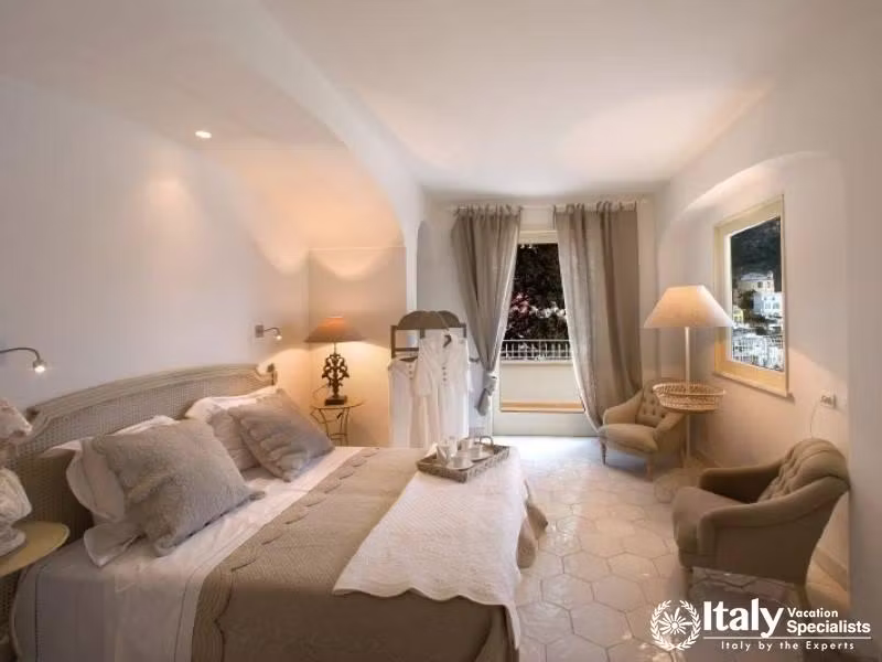 A cozy and elegantly furnished bedroom with a beautiful view.