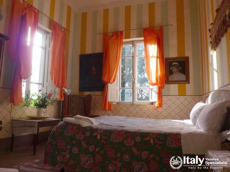 Bright and colorful bedroom with striped walls and orange curtains.