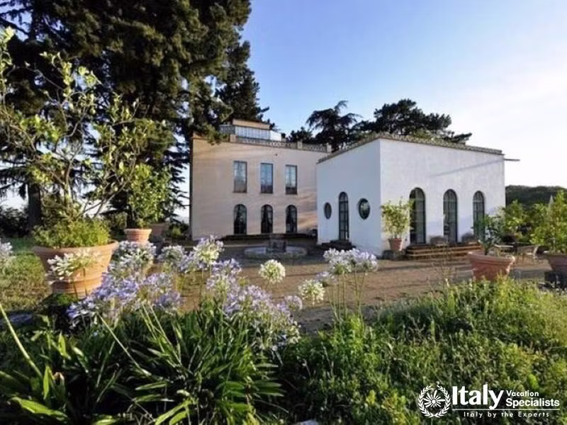 Charming villa surrounded by lush gardens and flowers.