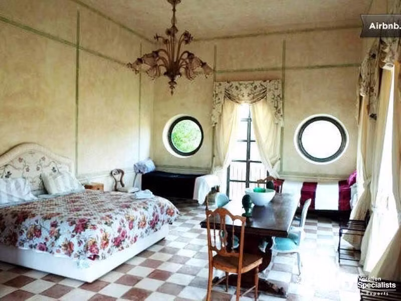 Elegant bedroom with round windows and floral decor.