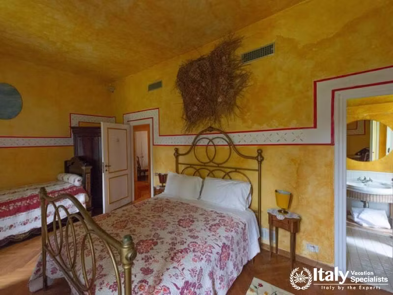 Inviting bedroom with floral bedding and warm yellow walls.