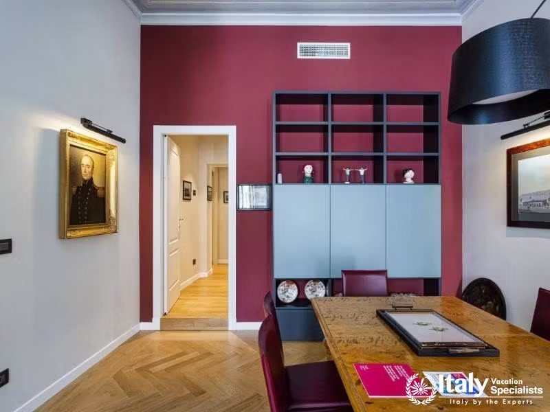 Elegant dining space with red shelving and curated decor.