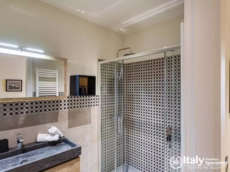 Modern shower room with patterned tiles and sleek design.