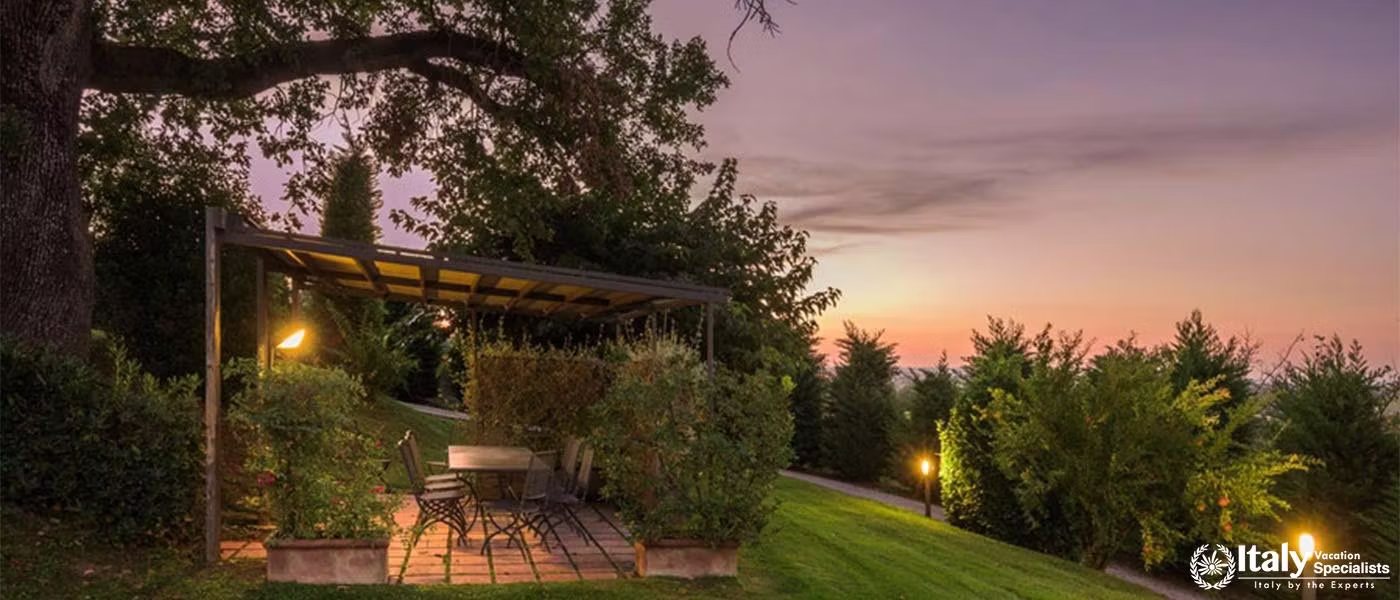 A cozy gazebo set in a garden at dusk, offering a quiet retreat with scenic views.