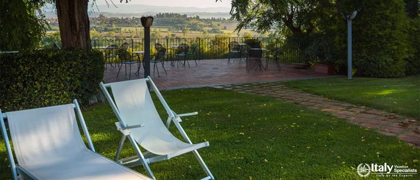 A patio with chairs overlooking a sweeping landscape.