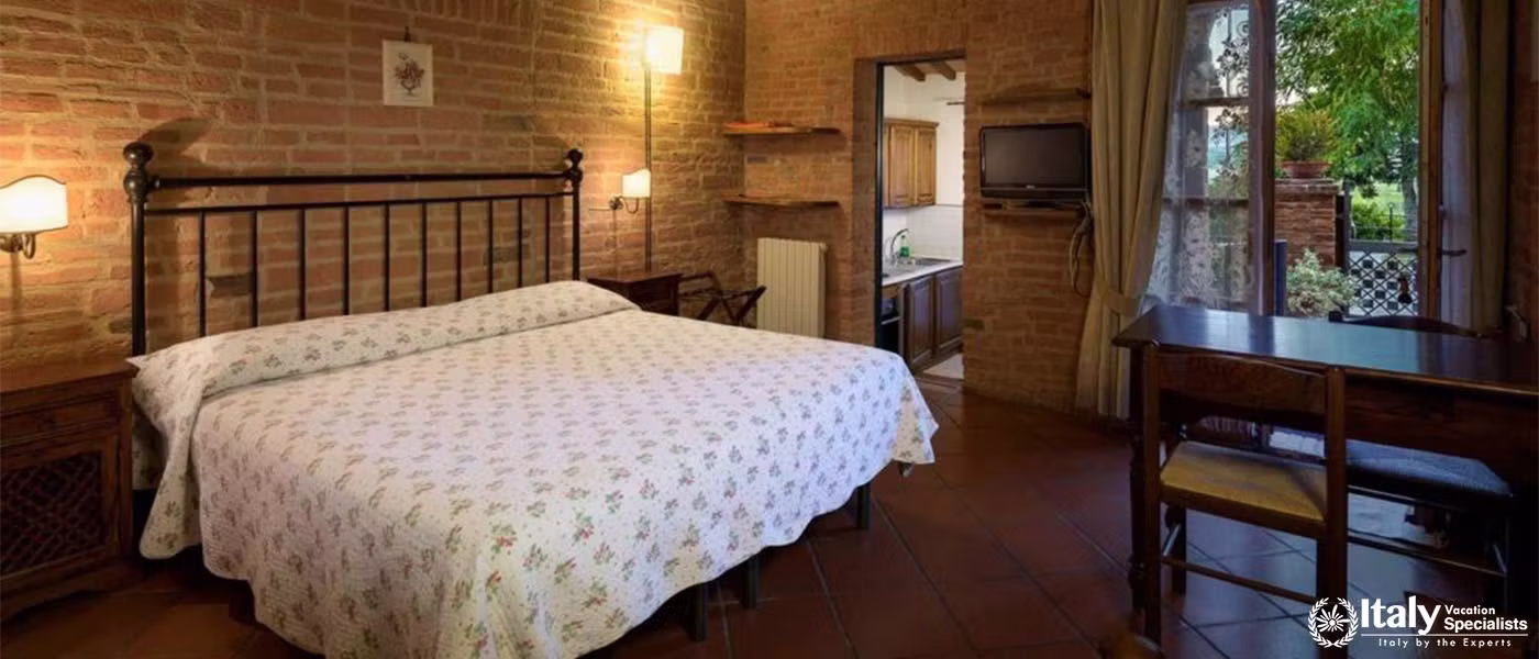 A cozy, rustic bedroom with a view of the garden through a French window.