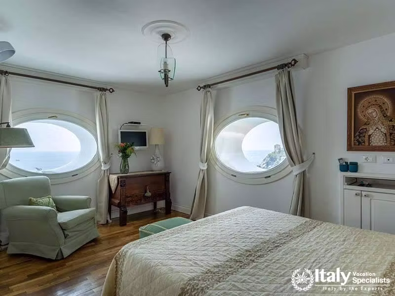 Bright Bedroom with Twin Circular Windows Overlooking the Ocean - In Villa Dei Sogni in Amalfi Coast