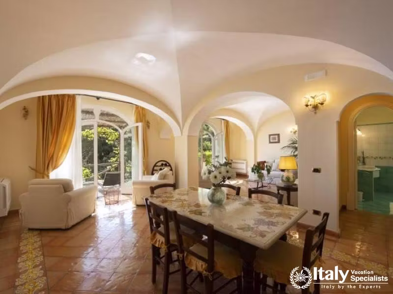 Spacious living and dining room featuring arched windows and doors.