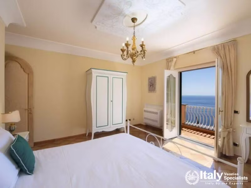 A tranquil bedroom with a coastal-inspired aesthetic and breathtaking balcony views.