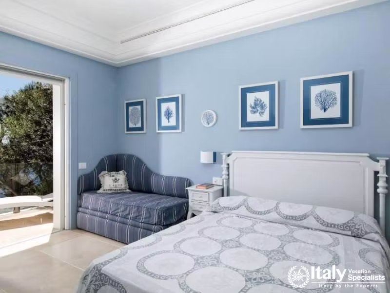 Cozy blue-themed bedroom with a sea view.