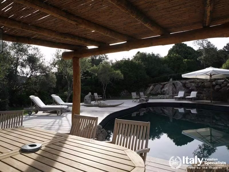 Swimming pool with dinning area besides it in Villa Piera