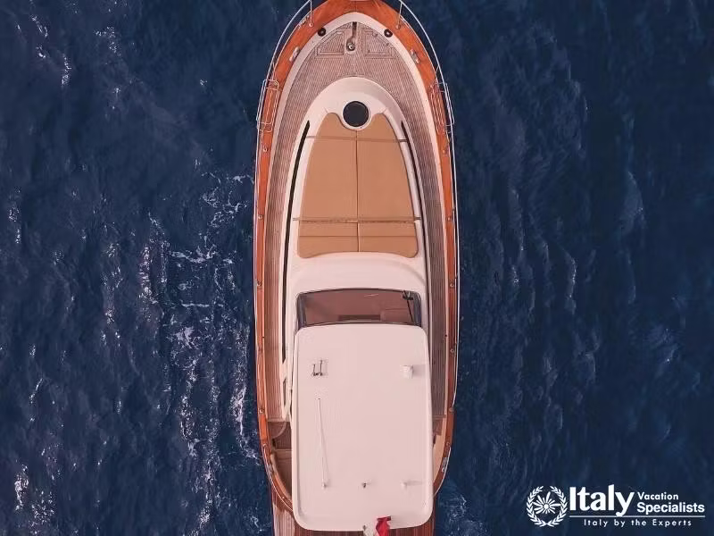 Top-down view of a luxury yacht cruising through the blue waters.